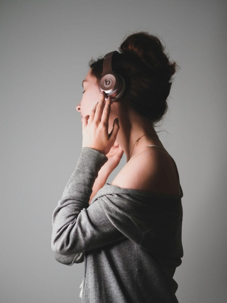 Woman lowering headphone volume, healthy habit to protect hearing over time
