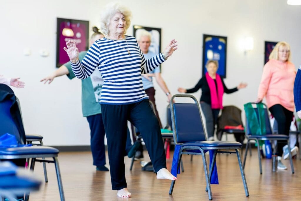 Older adult practicing a standing balance exercise at home