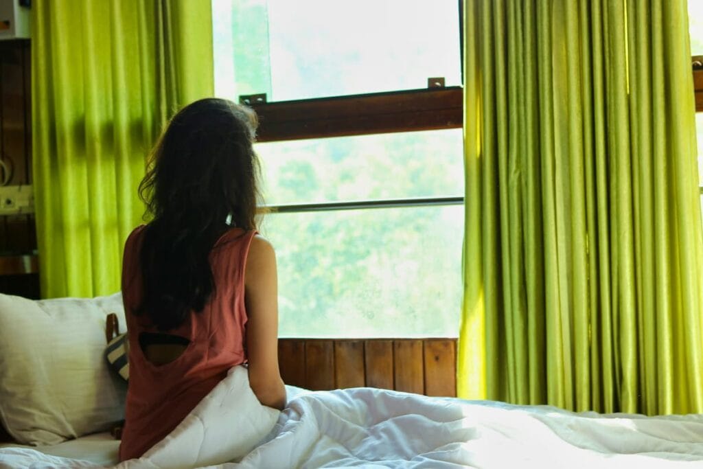 Woman sitting on the edge of the bed in the morning, early sign of joint stiffness, gentle mobility routine concept