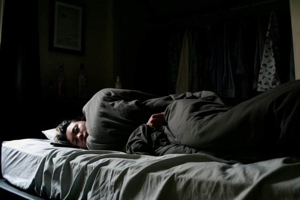 Woman lying awake at night noticing ringing in her ears in a quiet room, natural tinnitus support supplement concept