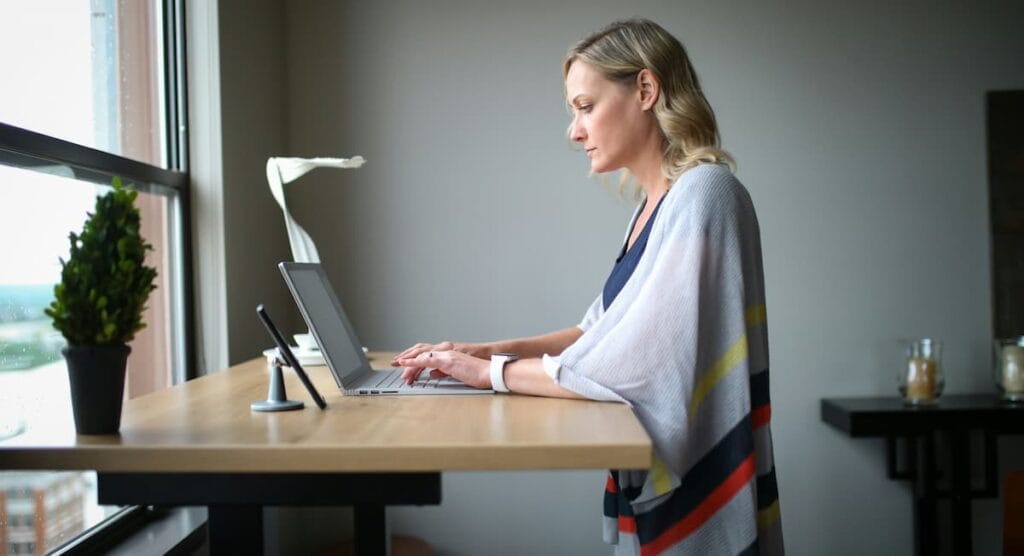Person practicing good posture at a desk to help reduce TMJ-related tension